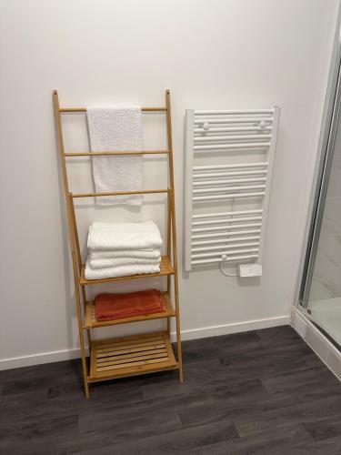 - une pile de serviettes sur un porte-serviettes à côté d'une fenêtre dans l'établissement Apartement95, à Sarcelles