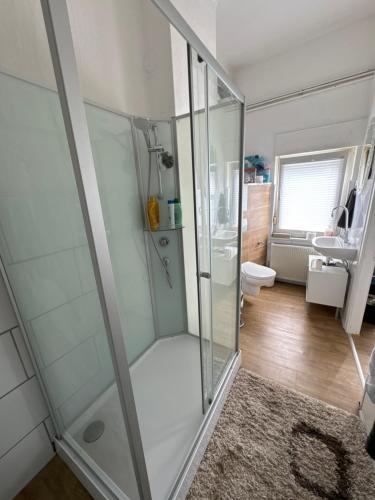 a bathroom with a shower with a glass door at Schelder Gästezimmer in Dillenburg