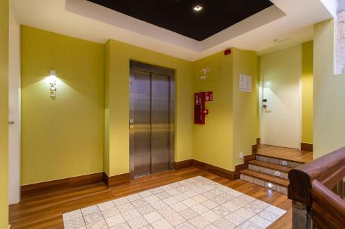 un pasillo con paredes amarillas y ascensor en Rosal by Seaward Suites Only Adults, en Villajoyosa