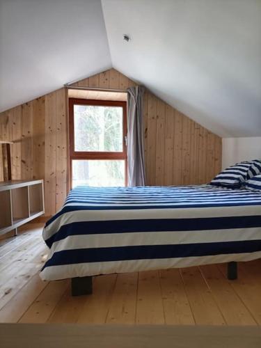 une chambre avec un lit et une fenêtre dans l'établissement Un gîte sur une île, à Saint-Bonnet-de-Rochefort