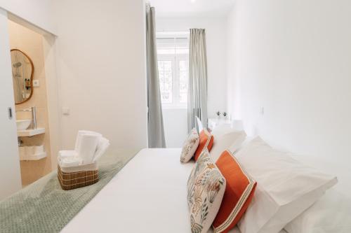 a white bedroom with a bed with pillows and a window at Oporto Yellow Villas in Porto