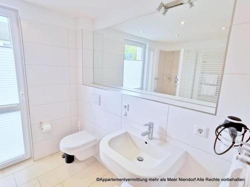 a white bathroom with a sink and a toilet at Apartmentvermittlung Mehr als Meer - Objekte 42 & 51 in Niendorf