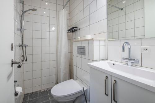 a bathroom with a toilet and a sink and a shower at HOTEL SØMA Sisimiut in Sisimiut