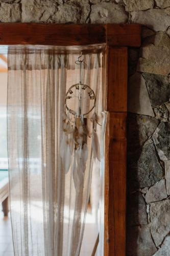 a chandelier hanging from a stone wall with a window at NaNa House Ericeira - Yoga & Surf in Santo Isidoro