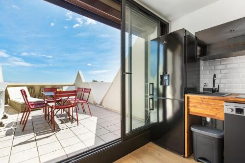 Il comprend une cuisine avec un balcon doté d'une table et de chaises. dans l'établissement Coco beach Heliopolis, au Cap d'Agde