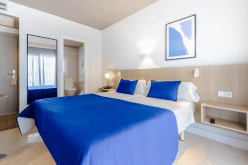 a blue and white bedroom with a large bed at Cabot Playa Grande - Adults Only in Playa de Palma
