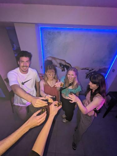 a group of people standing in a room eating food at Black Swan Hostel Granada in Granada