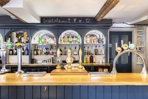 um bar num pub com um balcão com bebidas alcoólicas em The Fleur de Lys em Cranborne