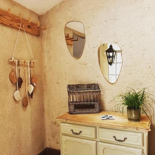 une salle de bain avec une commode avec un miroir et un panier dans l'établissement Duplex à colombages en bord de Loire à 2 pas du château de Blois, à Blois