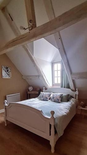 une chambre avec un lit blanc dans un grenier dans l'établissement Duplex à colombages en bord de Loire à 2 pas du château de Blois, à Blois