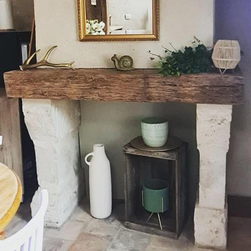 une cheminée avec un manteau en bois avec un miroir et un vase dans l'établissement Duplex à colombages en bord de Loire à 2 pas du château de Blois, à Blois