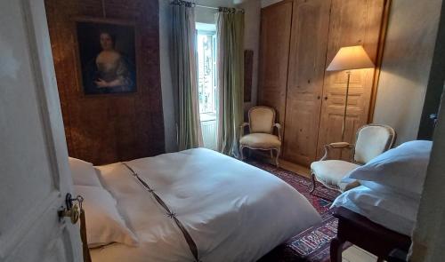 a bedroom with a bed and two chairs and a window at Bérard in Intres