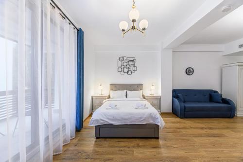 a bedroom with a bed and a blue chair at Alpin Clabucet Studio in Predeal