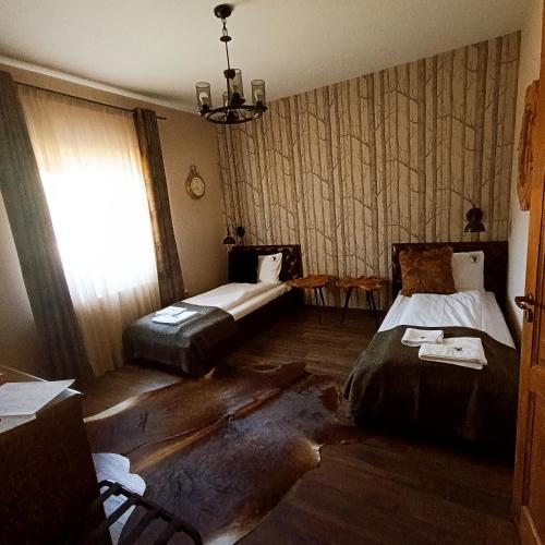 a room with two beds and a window in it at Tekeres-patak Fogadó in Pálosvörösmart