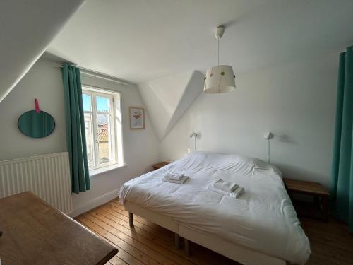 une chambre avec un lit blanc et une fenêtre dans l'établissement Villa Clin d'œil - Villa De knipoog, à Wimereux