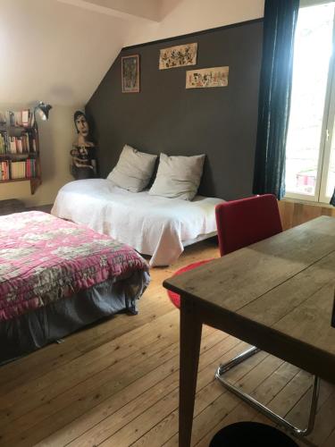 een slaapkamer met een bed, een tafel en een stoel bij Grande chambre 3 couchages in Parmain