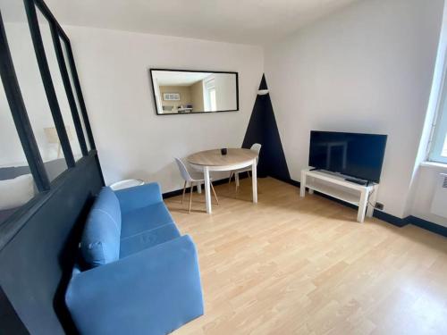 un salon avec un canapé bleu et une table dans l'établissement Studio près de la mer avec vélos, à Concarneau