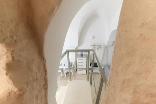Una escalera que conduce a una habitación con una pared de piedra en Terrazza GiuMaSe by Wonderful Italy, en Ostuni