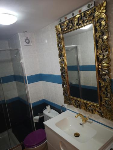 a bathroom with a sink and a mirror and a toilet at Puerto de Mogan Sonneland in Puerto de Mogán