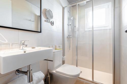 a bathroom with a toilet and a sink and a shower at Cabot Playa Grande - Adults Only in Playa de Palma