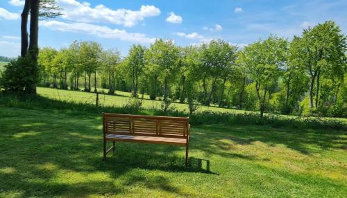 ławka w parku siedząca w trawie na polu w obiekcie Ferienhaus Kirschblüte w mieście Monschau