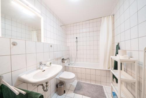 a white bathroom with a sink and a toilet at 2 Zimmer mit Balkon, Wohnzimmer mit Arbeitsplatz, zentral, top! in Fürstenwalde