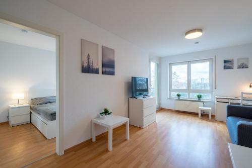 um quarto com uma cama, uma televisão e um espelho em 2 Zimmer mit Balkon, Wohnzimmer mit Arbeitsplatz, zentral, top! em Fürstenwalde