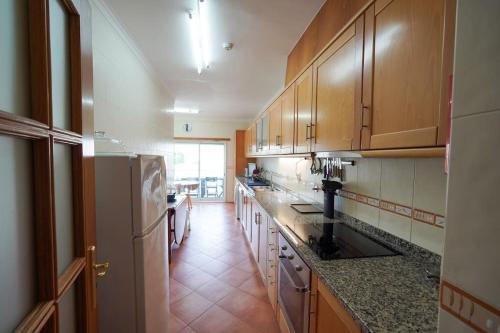 - une cuisine avec des placards en bois et un comptoir dans l'établissement Apartamento Edifício Horizonte, à Nazaré