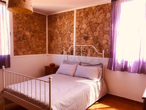 a bedroom with a bed and a wall of logs at Apartamento Joshualba II in Mesquer