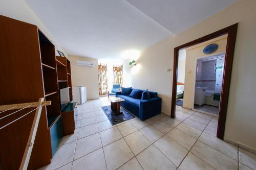 a living room with a blue couch and a kitchen at Hotel Majestic Olimp All Inclusive in Olimp