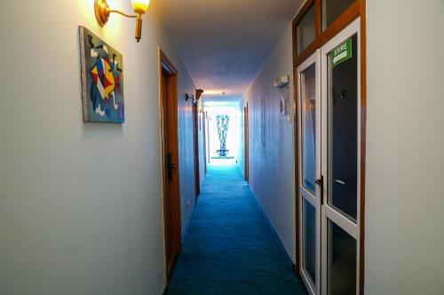 a hallway with blue carpeting and a hallway with doors at Hotel Majestic Olimp All Inclusive in Olimp