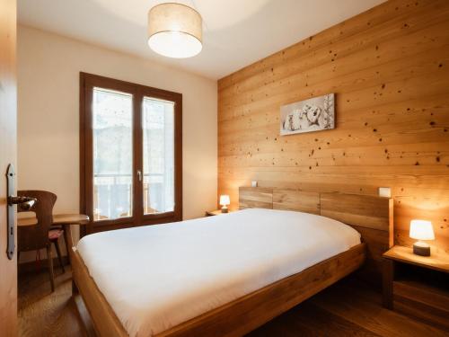 une chambre avec un lit et un mur en bois dans l'établissement 3***, proche pistes, ensoleillé, Wi-Fi, parking - FR-1-304-183, à La Clusaz