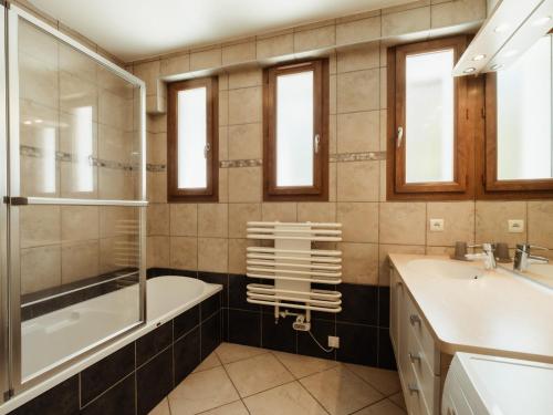 une salle de bain avec une baignoire et un lavabo et une baignoire tubermottermott dans l'établissement 3***, proche pistes, ensoleillé, Wi-Fi, parking - FR-1-304-183, à La Clusaz