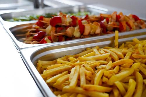 a bunch of french fries in trays of food at Hotel Majestic Olimp All Inclusive in Olimp
