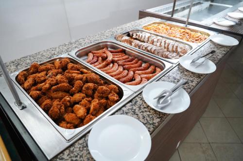 a buffet with several trays of meats and other food at Hotel Majestic Olimp All Inclusive in Olimp