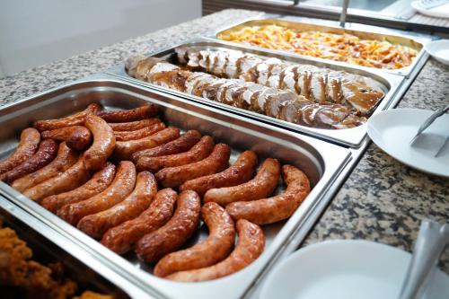 a buffet with trays of sausages and other food at Hotel Majestic Olimp All Inclusive in Olimp