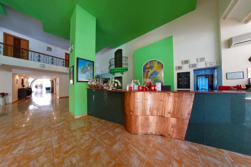 a bar in a large room with green walls at Hotel Majestic Olimp All Inclusive in Olimp