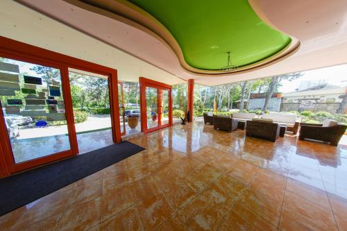 a large room with a green ceiling and tables and chairs at Hotel Majestic Olimp All Inclusive in Olimp