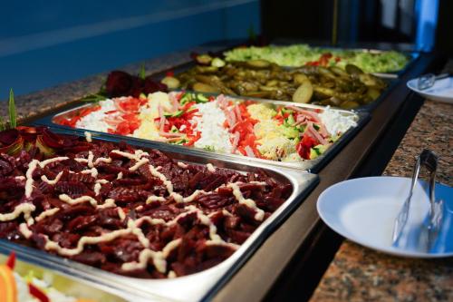a buffet with several trays of food on a table at Hotel Majestic Olimp All Inclusive in Olimp