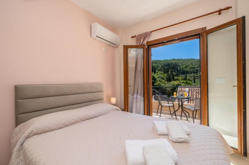 een slaapkamer met een bed en een balkon met uitzicht bij Mariel House Fiskardo Kefalonia in Fiskardho