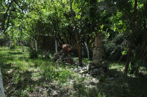 a garden with a pile of rocks in the grass at Загородный дом в горах, Габала in Corat