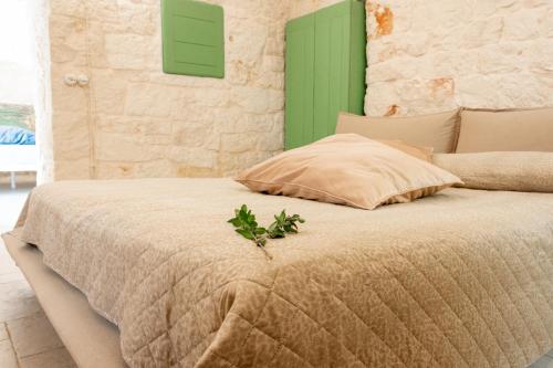 a bedroom with a bed with a green shutter at Trullo Nadia Ostuni in Ostuni