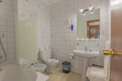 a bathroom with a toilet and a sink and a shower at Hotel Tres Jotas Conil in Conil de la Frontera