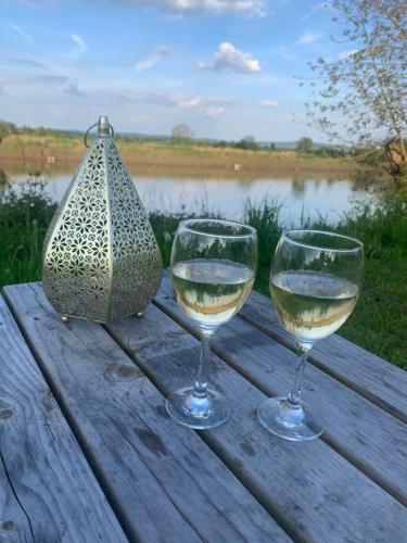 Westbury on Severn的住宿－Rivers View Holidays，木桌旁放两杯白葡萄酒