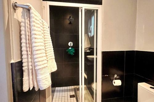 a bathroom with a shower with a glass door at Cozy condo in the heart of Maboneng in Johannesburg