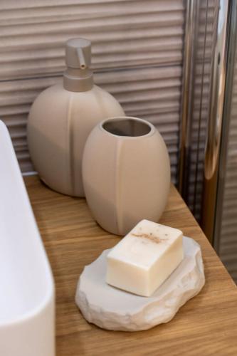 a block of butter sitting next to a cup on a table at Luxury 3BDR In The Heart Of Jerusalem in Jerusalem