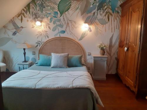 a bedroom with a bed with a floral wallpaper at 7 , le Haut Montrayé in Pacé