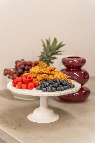 a plate of fruit on a table with a plate of grapes at Luxury 3BDR In The Heart Of Jerusalem in Jerusalem