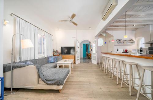 a living room with a bar and some stools at Manto Hotel in Mýkonos City