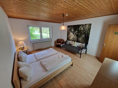 una grande camera da letto con un grande letto e un divano di Adventure Campus a Treuchtlingen